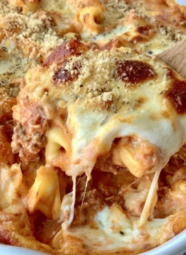 Cheesy baked tortellini casserole topped with meat sauce and cheese