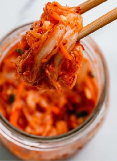 A bowl of vibrant homemade kimchi, showcasing fresh ingredients and spicy seasoning.